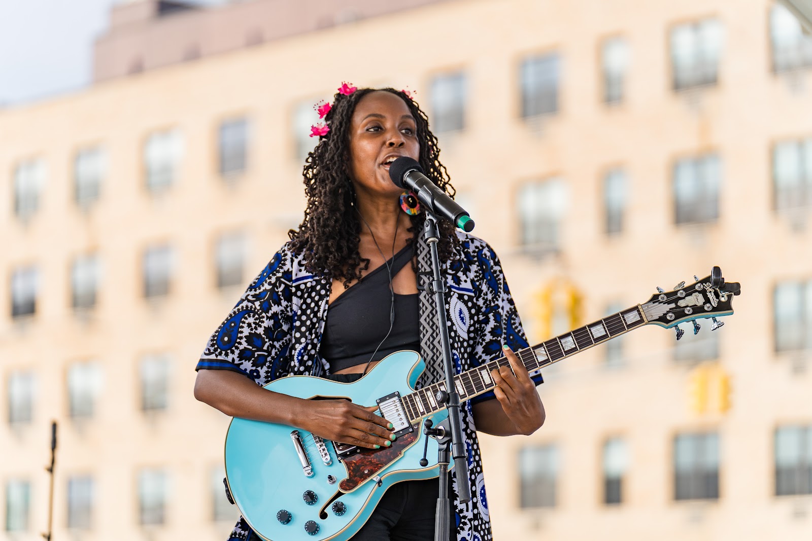 An artist performs with her guitar at a LiberArte community event